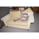 A modern two-seater settee upholstered in leaf scrolling material,