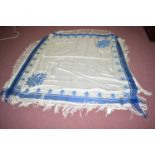 An early 20th Century silk shawl with blue floral and tassel decoration and border,