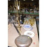 A brass companion set; a copper warming pan; a pair of brass candlesticks;