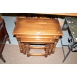 A late 20th Century stained oak nest of three graduated tables,