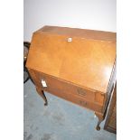 A mid 20th Century stained oak bureau, the fall-flap enclosing a fitted interior above two drawers,
