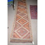 A Kilim runner in orange and brown colours, 69 x 294cms.
