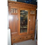 An early 20th Century oak Arts & Crafts three door wardrobe, by Maple & Co.