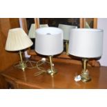 Three modern metal table lamps with shades.