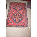 A Beluche rug with stylised geometric forms, 69 x 135cms.