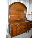 A mid 20th Century stained oak dresser, the arched delft rack with two shelves above,