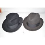Two trilby hats, by Dunn & Co. Ltd., in black and dark grey, inner rim 8 x 6 1/2in. and 8 x 6 3/4in.