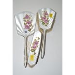 A three-piece enamelled silver-mounted dressing table set, to include: a hand mirror,