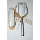 Two Art Deco silver-mounted brushes, each with white enamel and fleur de lys decoration,