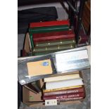 A box containing stamp albums; first day covers; and cigarette card sets.