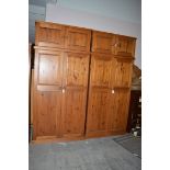 Two stained pine two door wardrobes; and two matching cabinets.