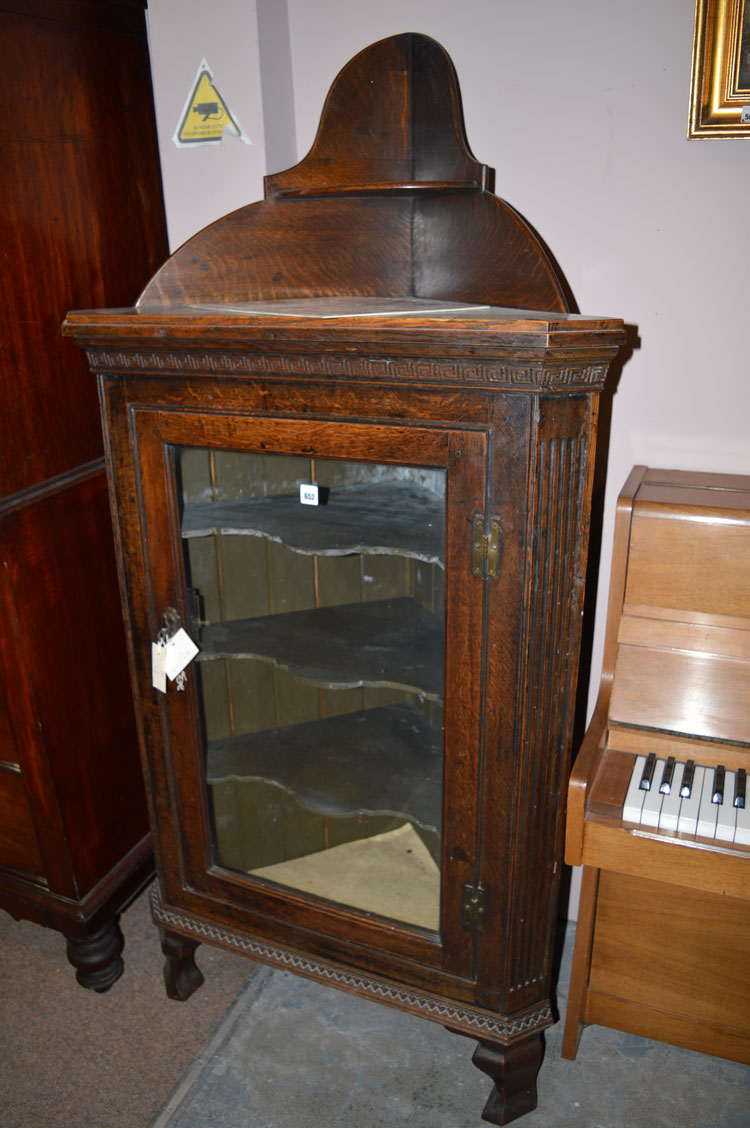 A 19th Century oak corner display cabinet, with glazed panelled doors enclosing shelves.