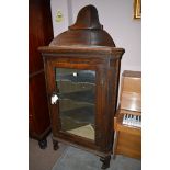 A 19th Century oak corner display cabinet, with glazed panelled doors enclosing shelves.