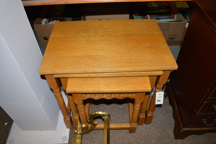 A nest of three light stained oak occasional tables.