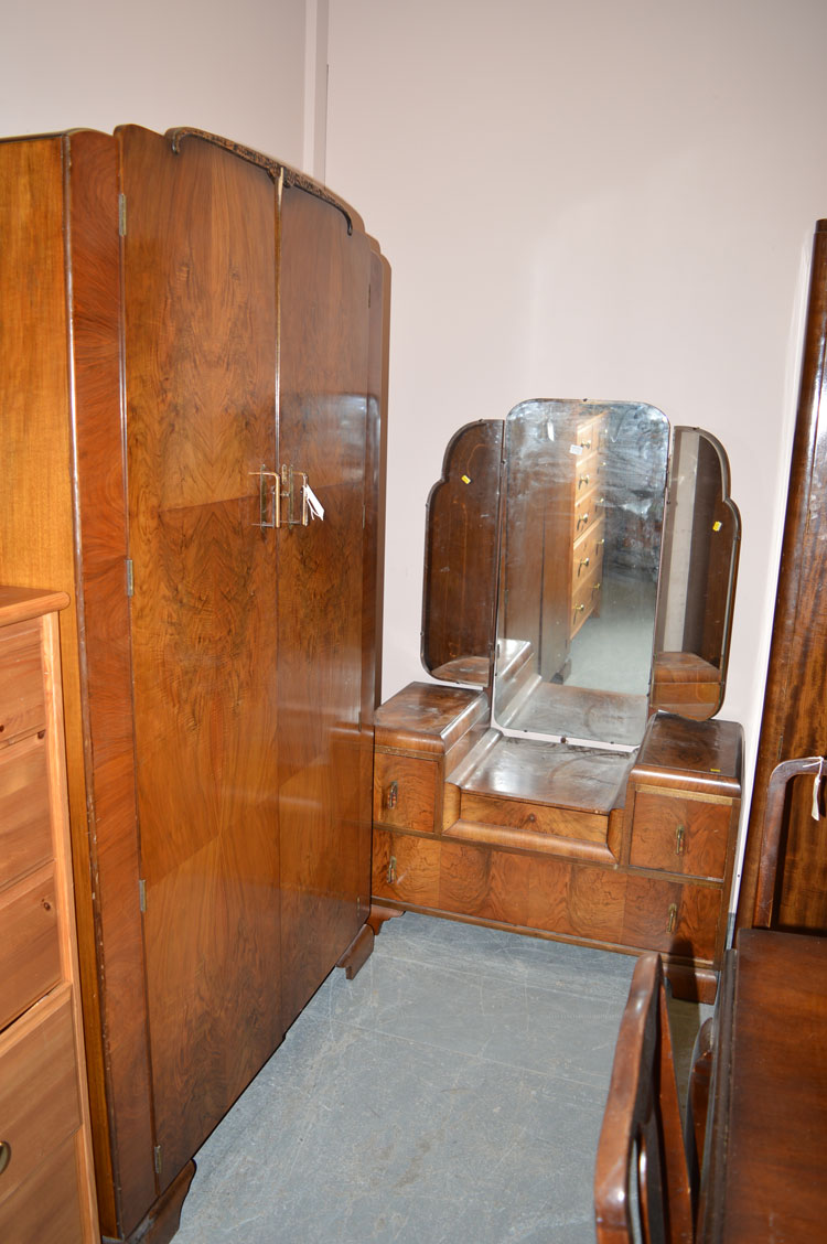 A mid 20th Century figured walnut walnut three-piece bedroom suite, to include: a two door wardrobe,