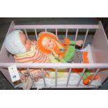 A doll's cot; together with three vintage dolls.