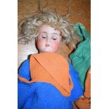 A German bisque head doll, inscribed 'Made In Germany 63', with rolling eyes,
