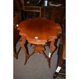 A stained wood shaped circular occasional table, raised on tapering legs joined by an undertier.