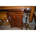 A reproduction inlaid mahogany miniature chest of four long drawers;