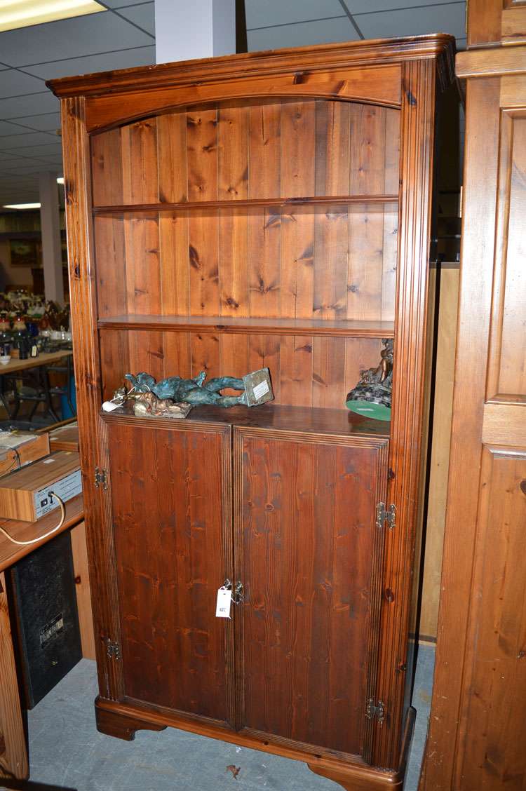 A stained pine bookcase, with later added panel doors.