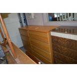 A pair of oak veneered chests of four long drawers.