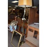 A brass extending standard lamp; and a 19th Century dressing table mirror with painted decoration.