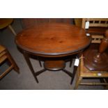 An Edwardian inlaid mahogany oval two-tier occasional table.