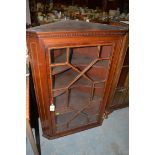 An Edwardian mahogany hanging corner cabinet, fitted astragal glazed door enclosing shelves.