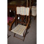 An early 20th Century stained wood folding armchair.