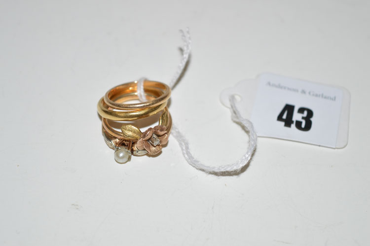 A diamond set flower pattern ring; a cultured pearl set ring; and two wedding bands.