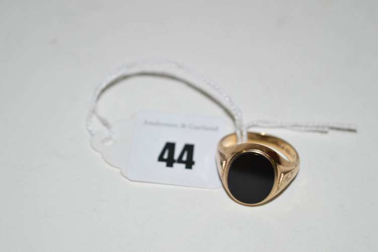 An onyx set signet ring, the blank oval onyx stone in 9ct. gold mount.