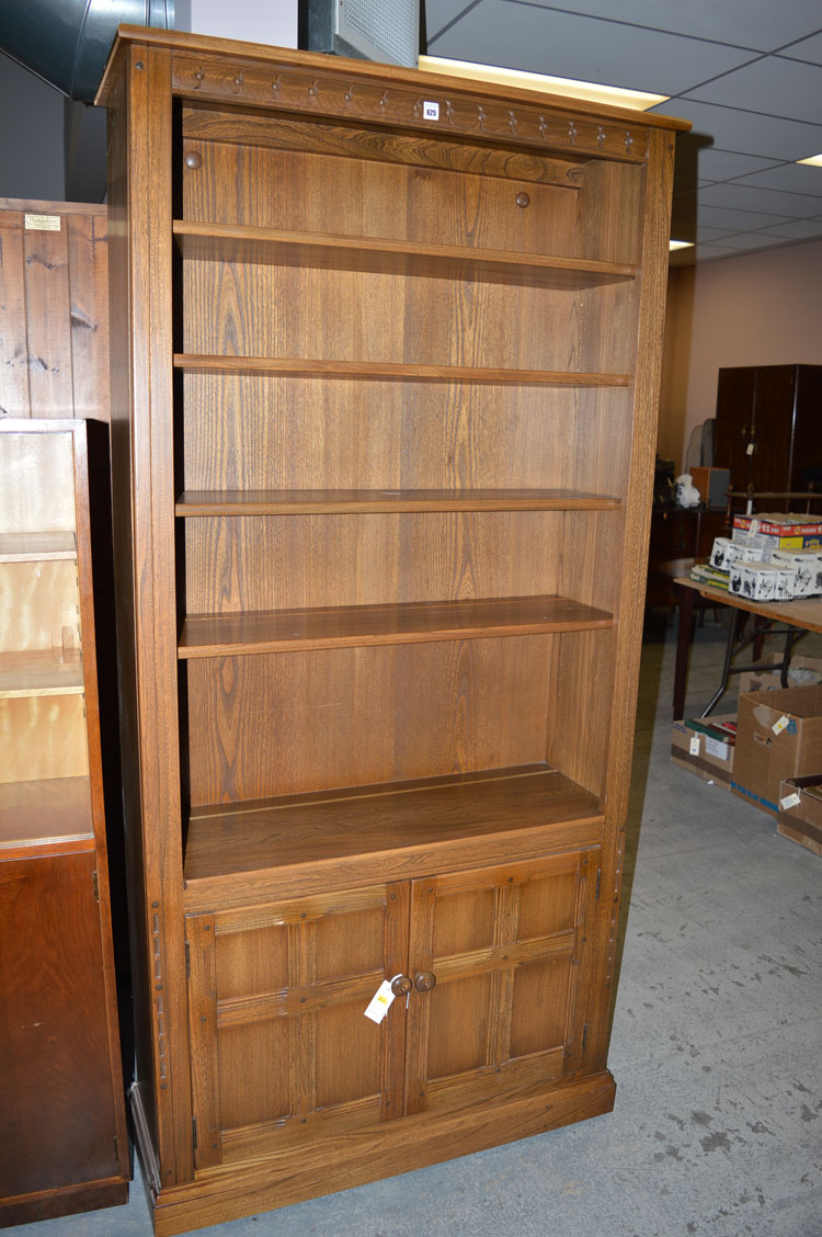 A dark stained wood open bookcase, with a pair of cupboard doors under.