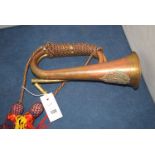 A copper bugle with military badge.