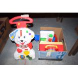A baby-walker in the form of a dog together with: a box of children's toys.