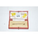 A cultured pearl mounted yellow metal bar brooch, stamped '9ct',