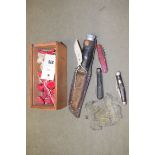 A box of collectables, to include: chess pieces; three pen knives; a sheath knife; and a mesh purse.