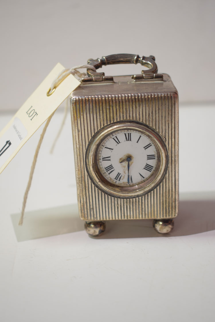 A silver cased dressing table clock, the white enamel Roman dial within reeded case, F.B.M.