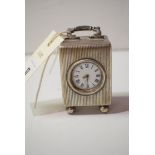 A silver cased dressing table clock, the white enamel Roman dial within reeded case, F.B.M.