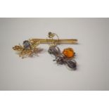 A fly pattern brooch set mystic topaz, stamped '10K'; another bug brooch; and a bar brooch.