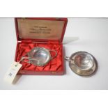 A white metal tea strainer on stand, in original case retailed by Charles. S. Green & Co.