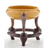 Yellow and aubergine tripod of censer form, on three slight scroll elongated legs, height 6.8cm.