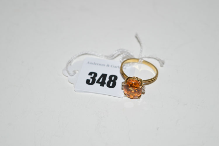 A citrine and diamond ring, the oval facet cut citrine flanked by pairs of diamonds, on 18ct.