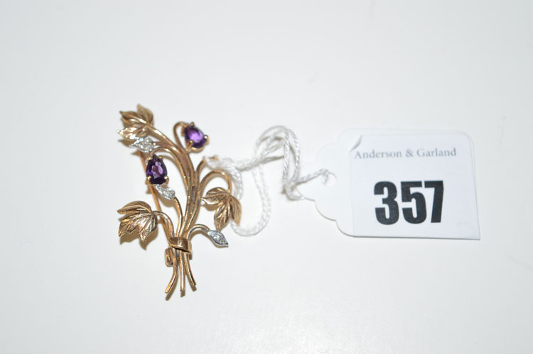 A diamond and amethyst set flower pattern brooch in 9ct. yellow gold.