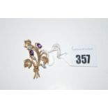 A diamond and amethyst set flower pattern brooch in 9ct. yellow gold.
