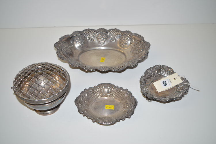 An oval pierced and embossed silver basket; two pierced and embossed bon-bons;