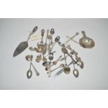 A silver tea strainer; together with various types of teaspoons; pickle forks; a cake slice; etc.