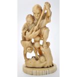 A carved Japanese bone figure of a man, holding a boy in a basket whilst he plays with a monkey,