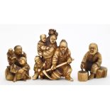 Three late 19th Century Meiji period Japanese carved groups, one of a man seated,