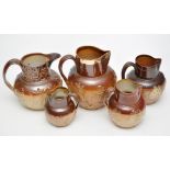 Five salt glaze stoneware jugs, with applied moulded tavern and hunting scenes, one with copper rim,