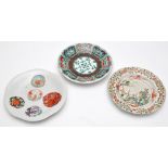 Three Japanese dishes, one painted in the manner of Chinese Famille Rose, the largest diameter 23cm.